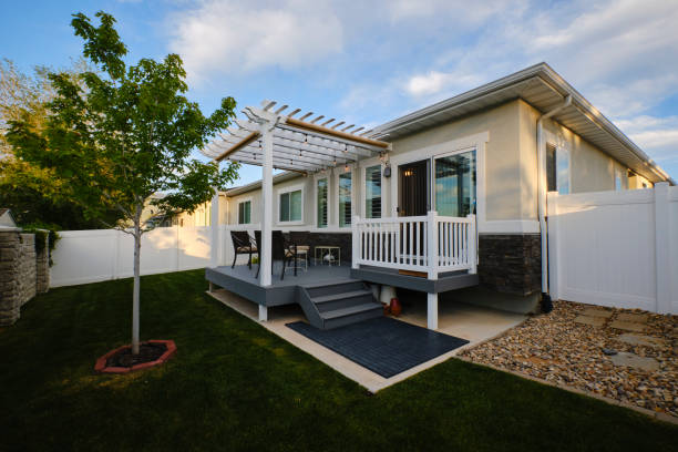 a backyard of a suburban usa home with a deck and pergola.